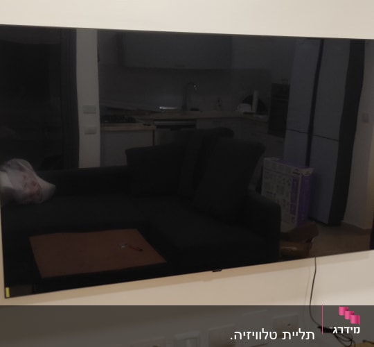 טלוויזיה תלויה על הקיר עם כבלים חשמליים